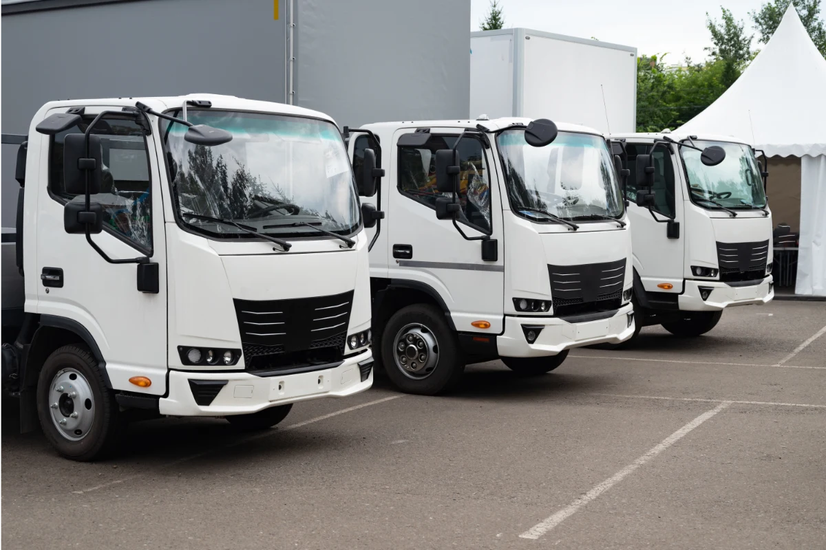 Fleet of white commercial trucks parked in a row