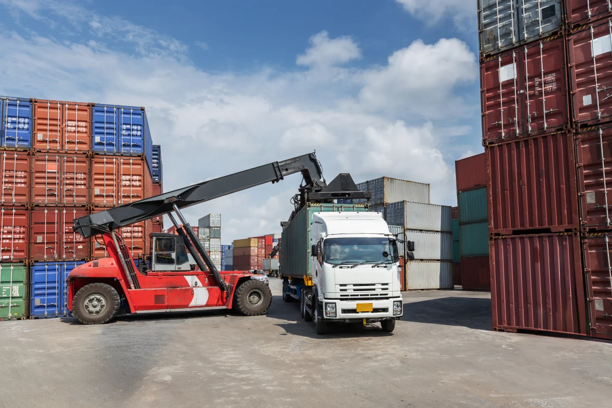Container handler loading a freight truck at a shipping yard