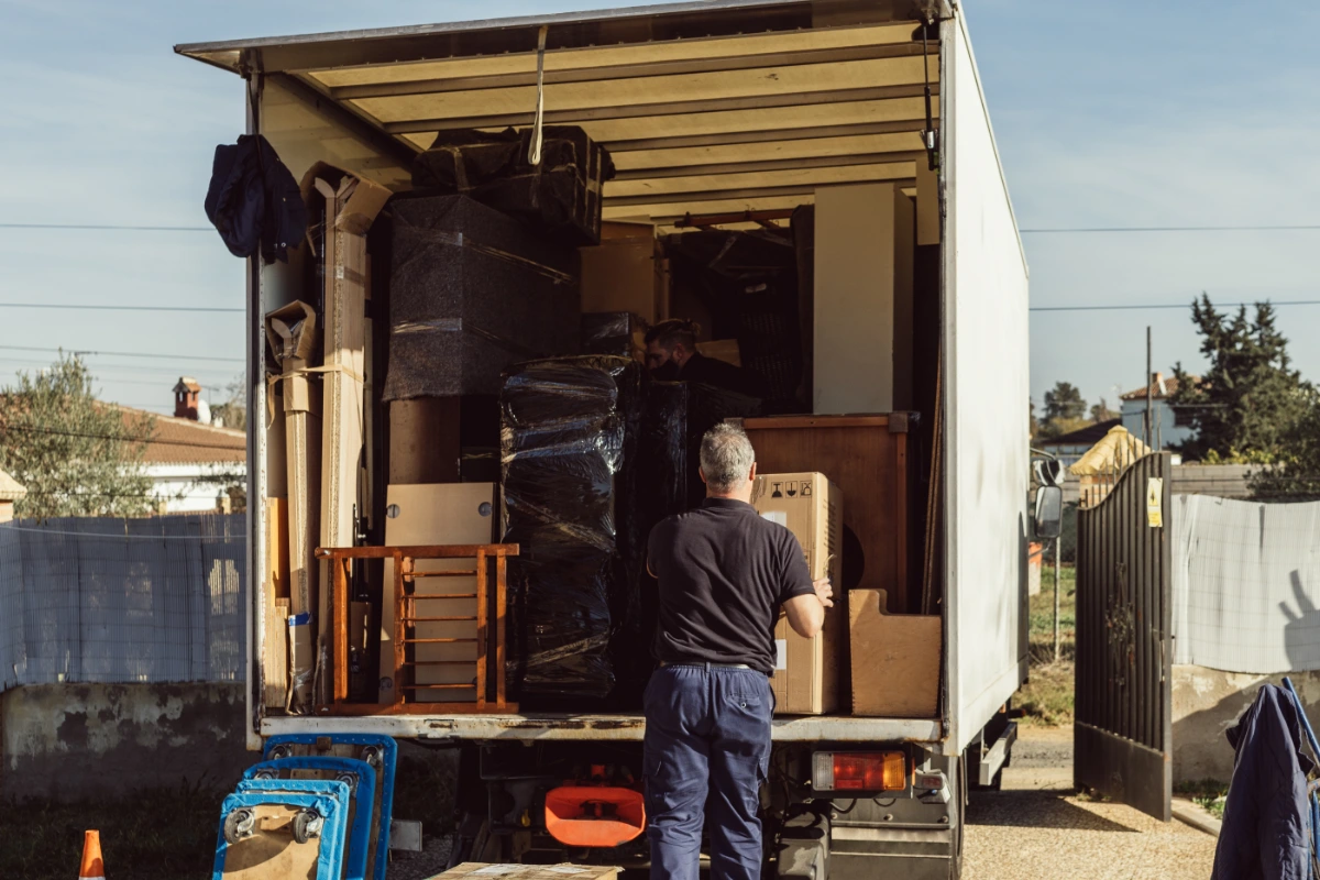 Delivery workers unloading furniture and boxes from a removal truck
