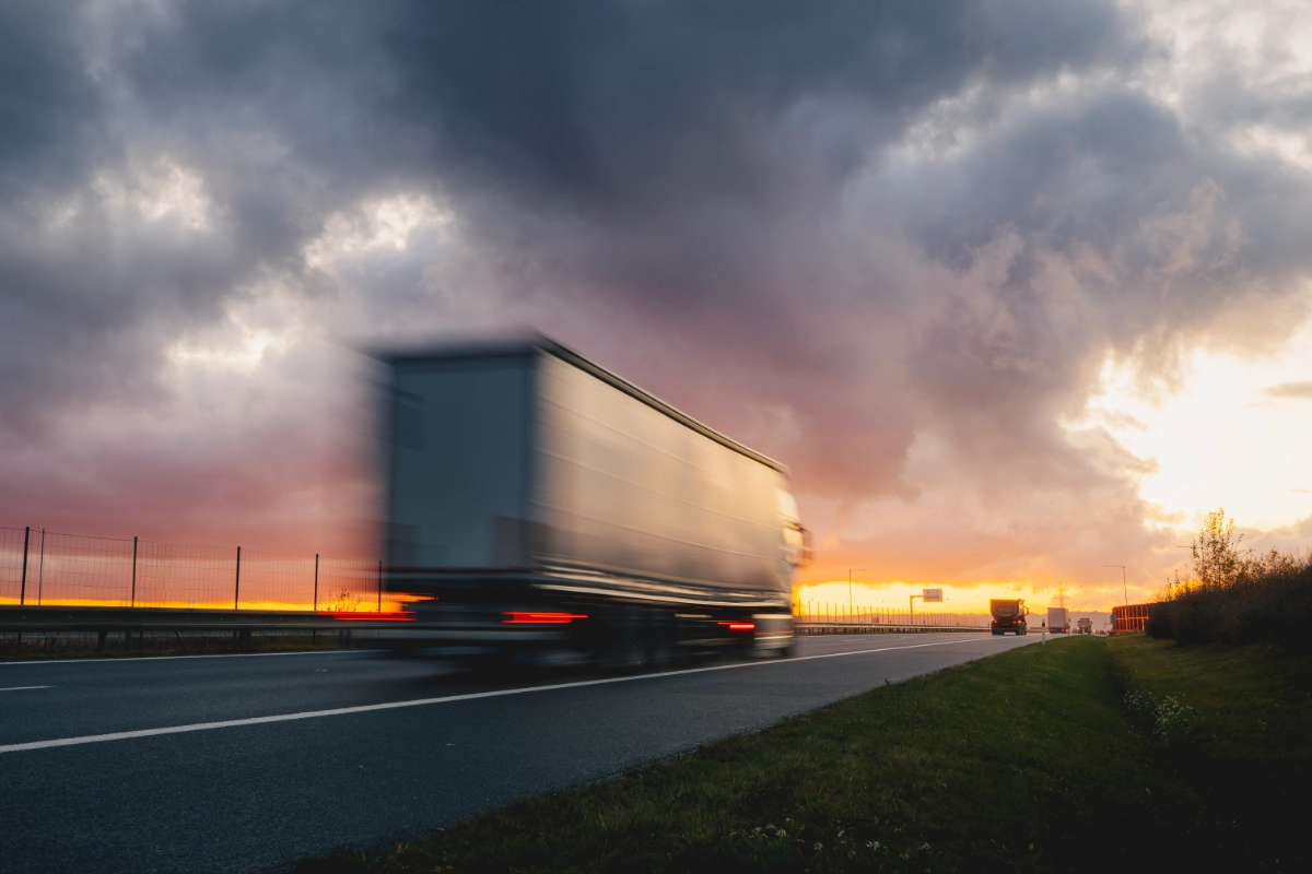 HGV lorries travelling on a motorway at sunset