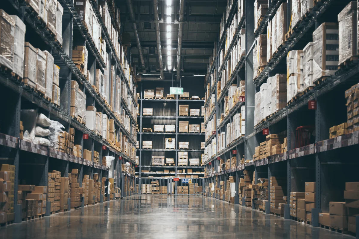 Industrial warehouse aisle with stacked boxes and palletised goods