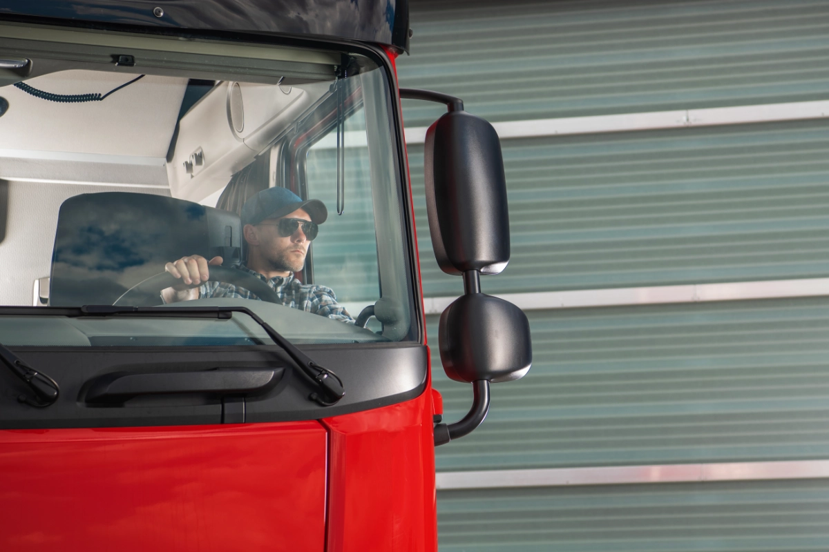 HGV driver sitting behind the wheel of a commercial lorry