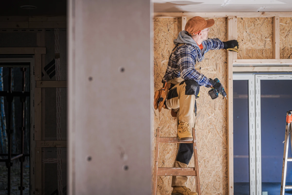 Construction worker fitting timber framing inside a property renovation