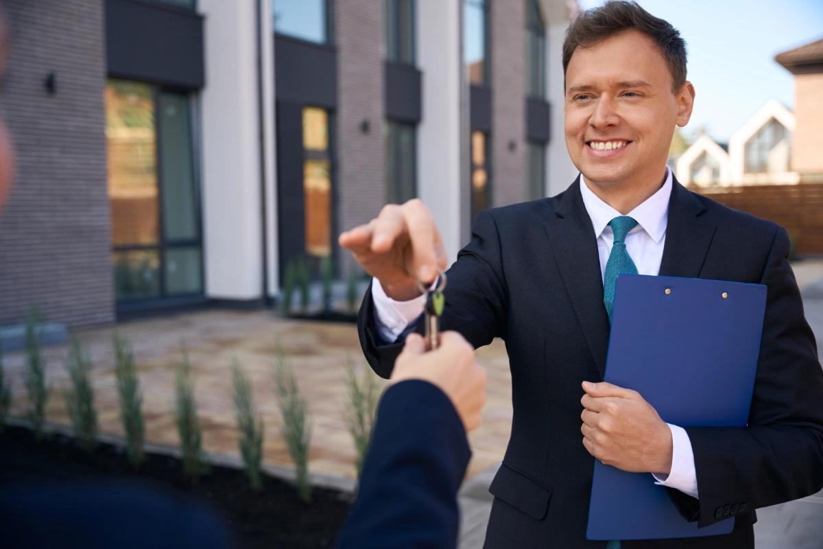 Property professional handing keys to a client outside a modern home