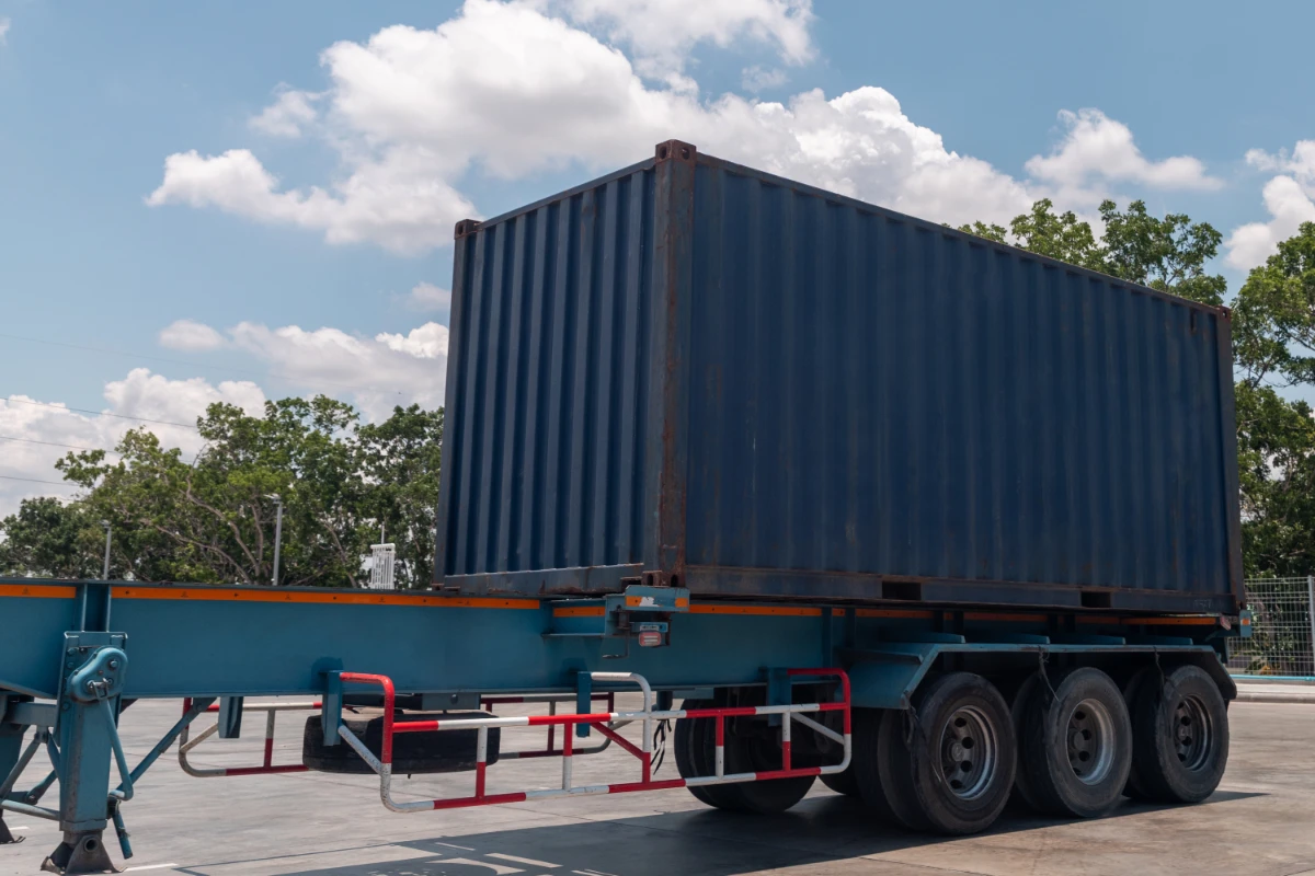 Shipping container secured on a commercial transport trailer